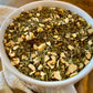 Basil pesto seasoning with dried garlic mix in a white ceramic bowl on a cloth napkin