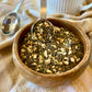 Basil pesto seasoning with dried garlic mix in a wooden bowl with a metal measuring spoon